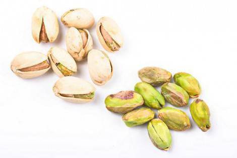 Several pistachio nuts naked and in shell close up isolated