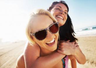 young-woman-two-friends-female-beach-laughing-fun-summer-660x468