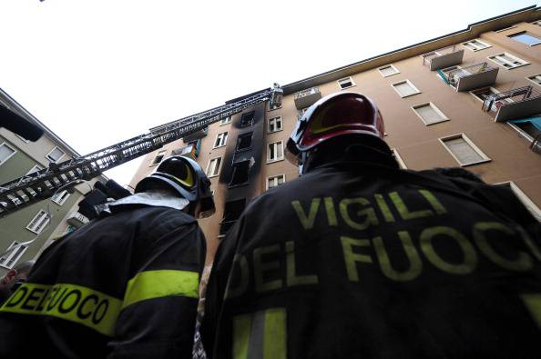 Firemen work near a building after a fir