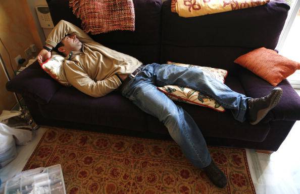 2006. Cadiz, Andalusia, Spain. Man sleeping a 'siesta' in the sofa of house.