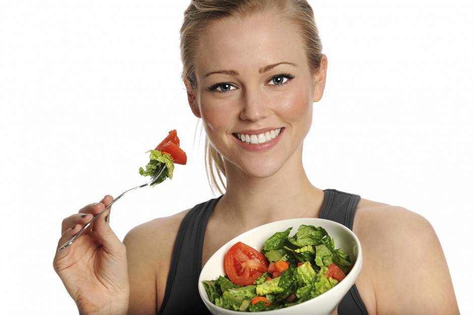 Healthy young woman eating salad
