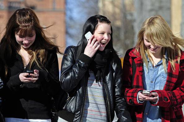 Teenagers use cell phones after school time in Vaasa on March 30, 2010.   AFP PHOTO OLIVIER MORIN. (Photo credit should read OLIVIER MORIN/AFP/Getty Images)