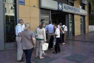Persona in fila al bancomat ad Atene (ANGELOS TZORTZINIS/AFP/Getty Images)