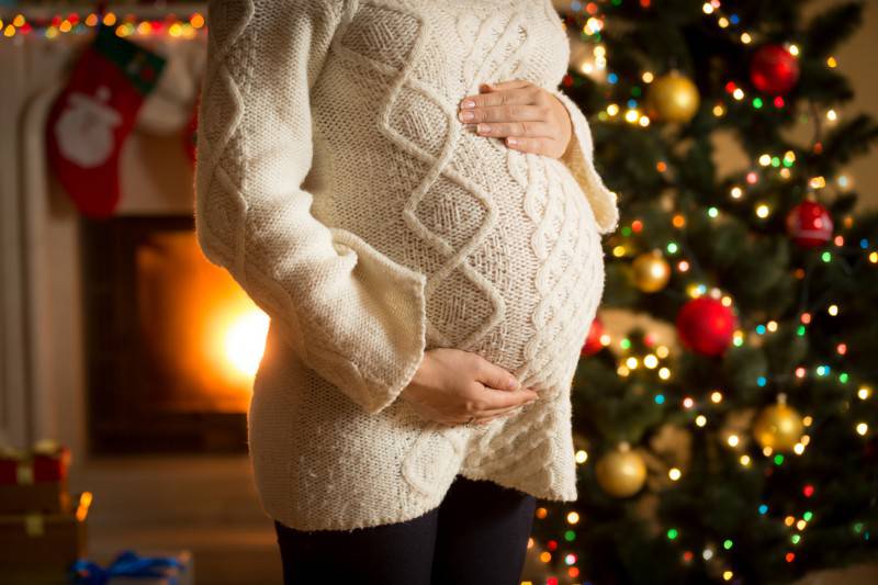 Donna incinta con albero di Natale (Thinkstock)
