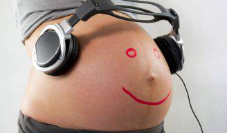Pregnant woman belly with smiley face and headset
