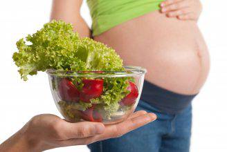 Pregnant woman holding fresh salad illustrating healthy eating