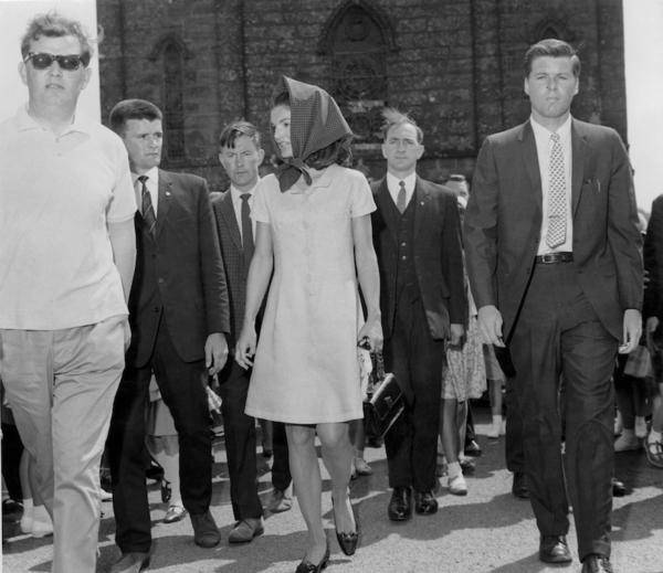 A posse of Irish Special Branch policemen and American Secret Service men escort Jacqueline Kennedy (1929 - 1994) from church after Mass, during a family holiday in Ireland, 20th June 1967. (Photo by London Daily Express/Getty Images)