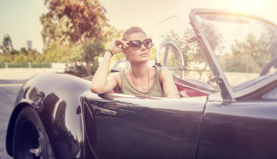 Beautiful woman sitting in cabriolet, sexy female enjoying trip on luxury modern car with open roof, fashionable lifestyle concept