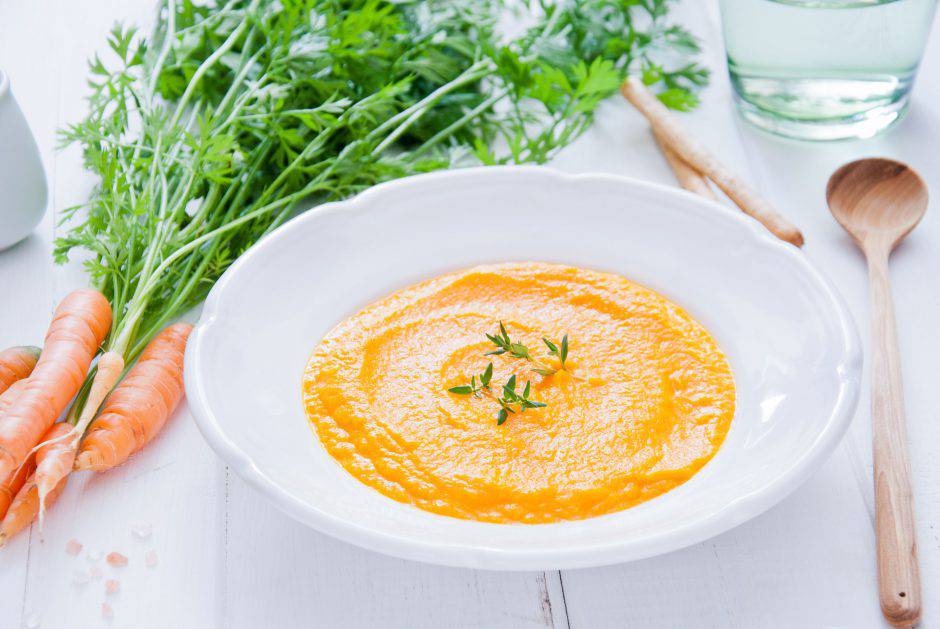 Creamy Carrot Soup on white wooden background