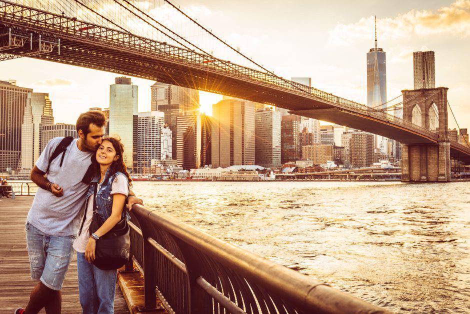 Young Couple Under Brooklyn Bridge at sunset