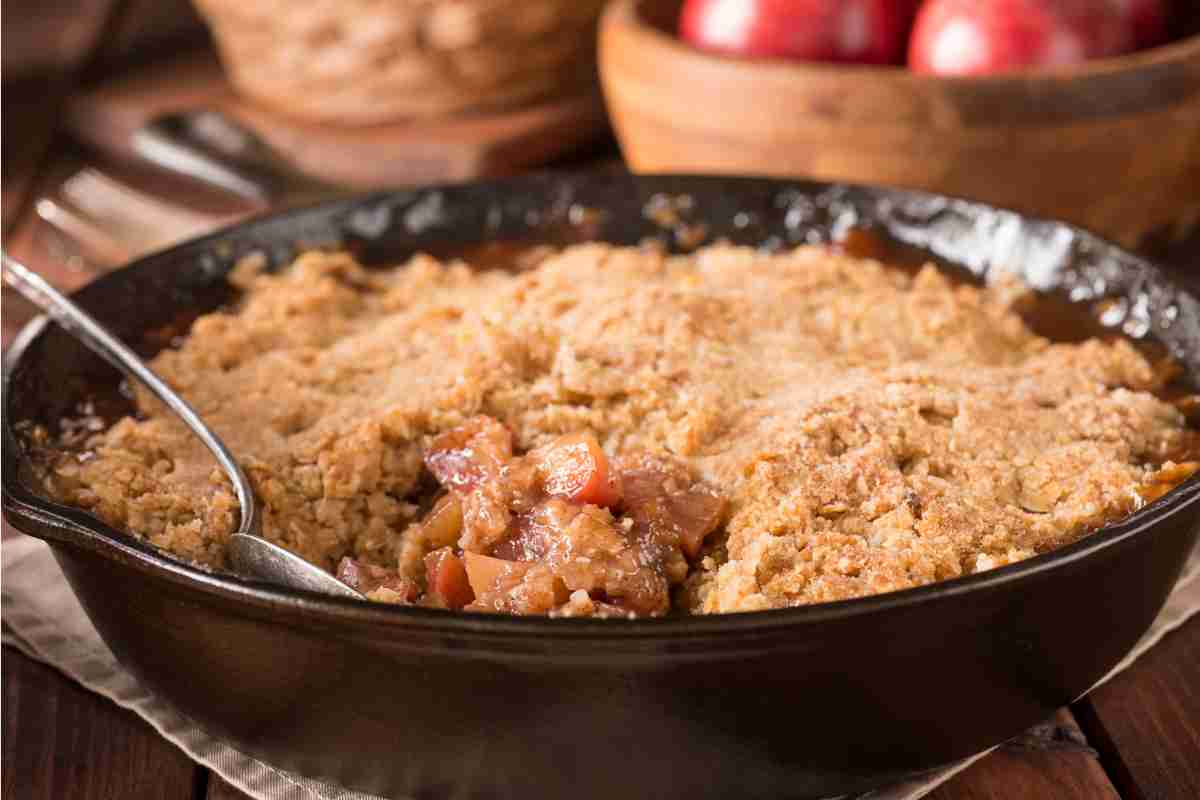 Crumble di mele in padella con mele sullo sfondo