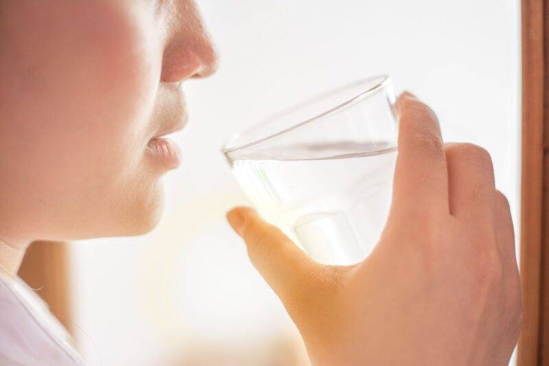 Donna che beve un bicchiere d'acqua