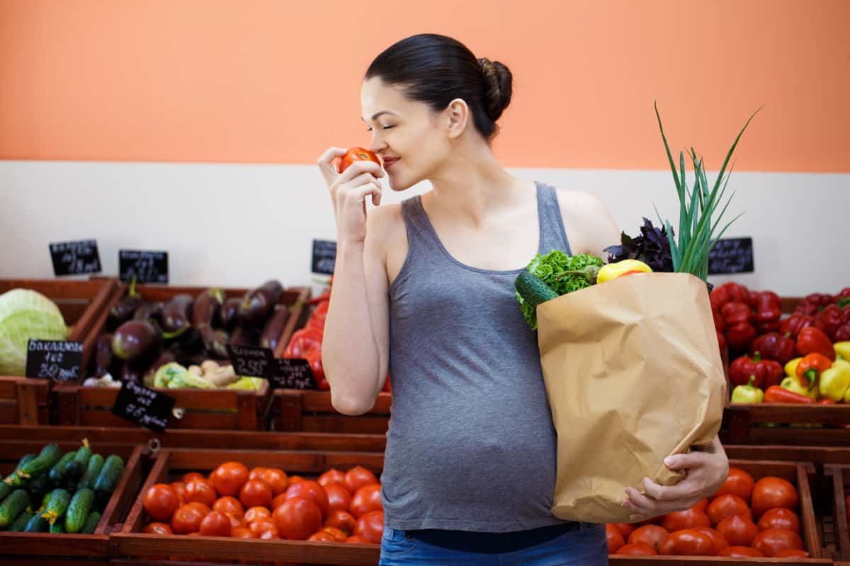 donna incinta tra frutta e verdura 