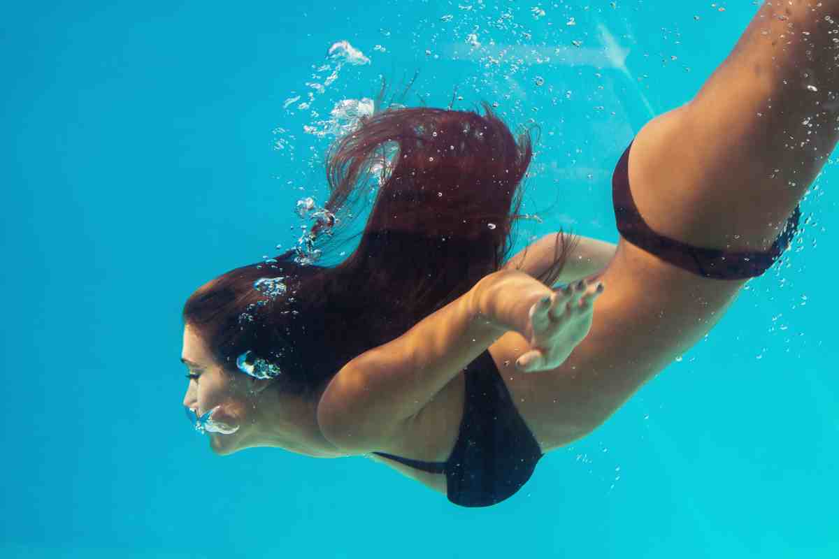 donna nuota sott'acqua come simbolo del significato di sognare di nuotare