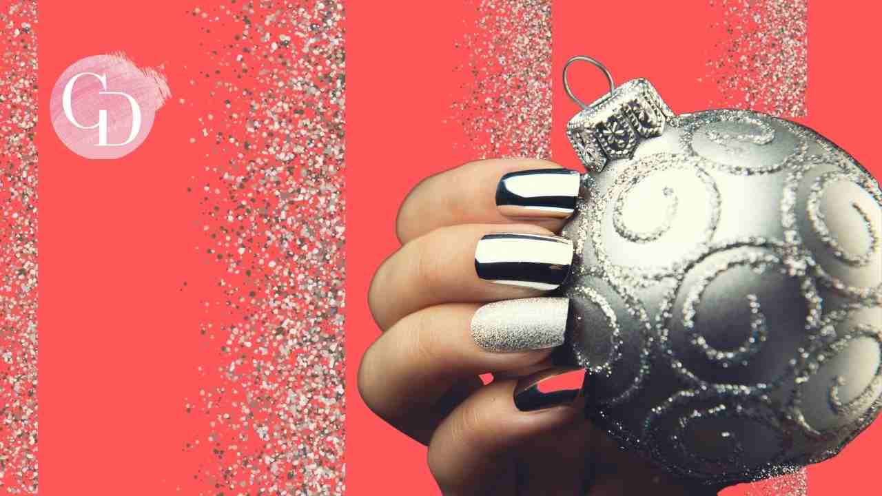 Glitter Nails mano con unghie argento che tiene sfera natalizia argentata