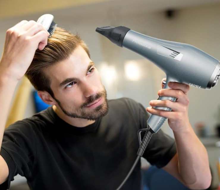 Un ragazzo che usa un phone sui capelli