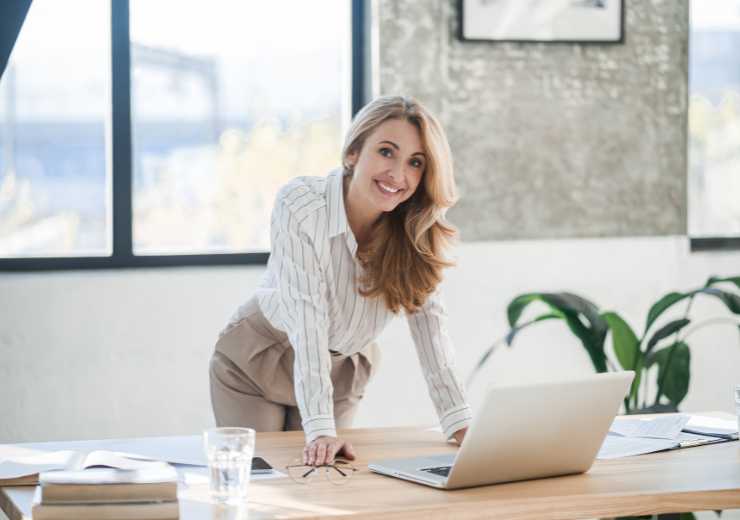 Donna in ufficio con pantalone chiaro e camicia