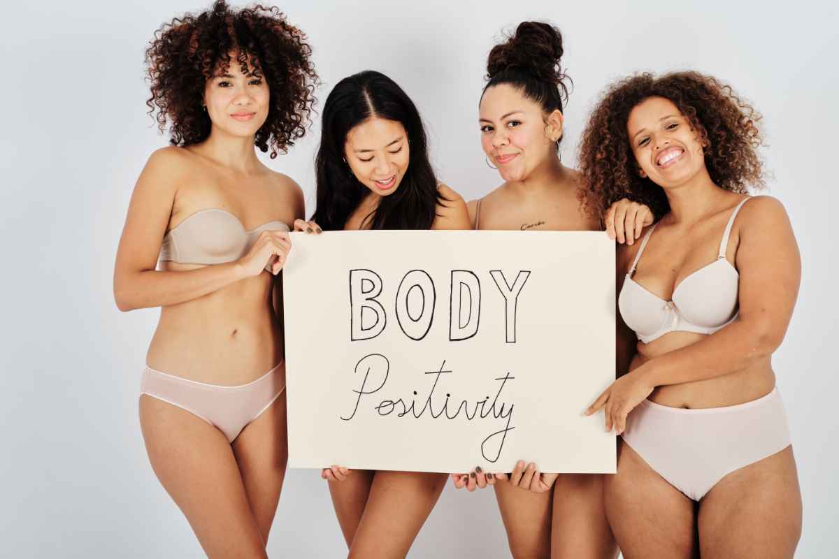 Influencer body positive in costume con cartello