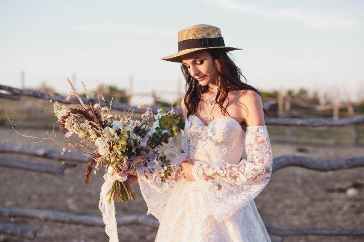 donna con abito da sposa boho chic e cappello