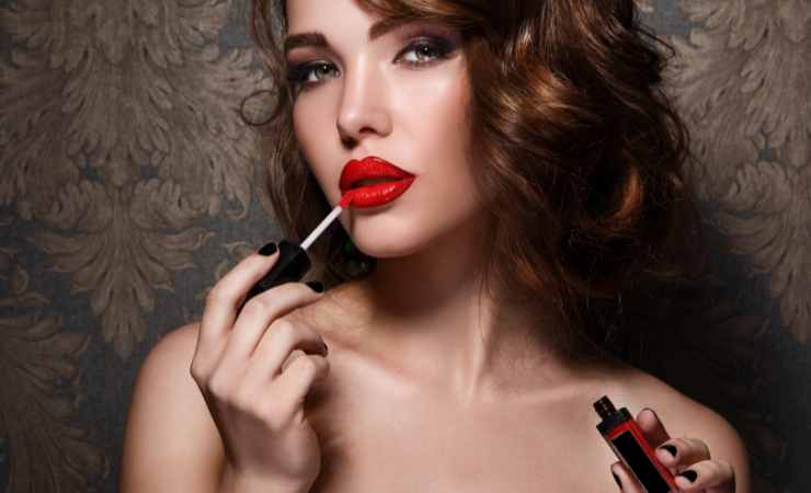 donna che applica il rossetto sulle labbra rosso