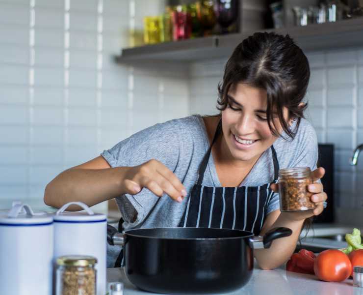 Donna che cucina con pentola nera