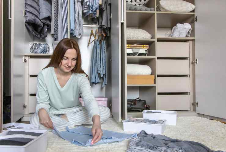 Donna che piega vestiti nell'armadio