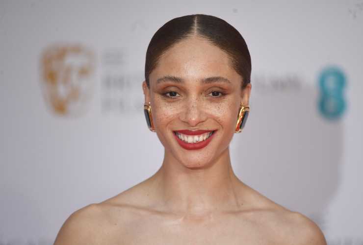 Adwoa Aboah  in primo piano con capelli legati e rossetto rosso