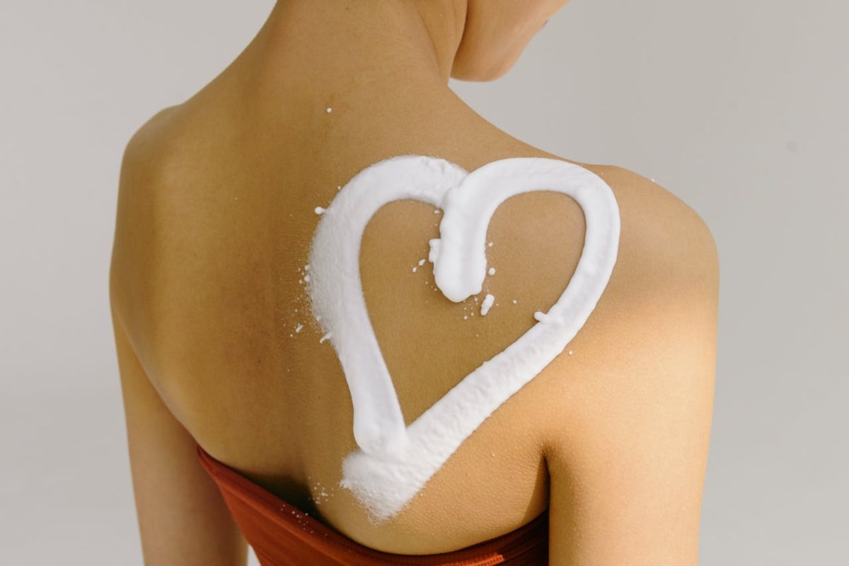 Crema corpo a forma di cuore sulla spalla