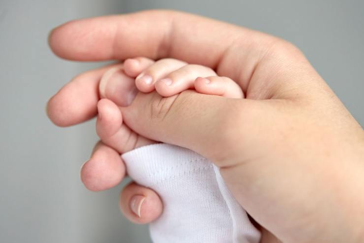 mano neonato nella mamma 