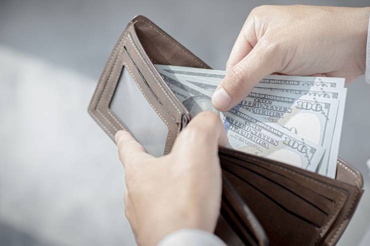 mano che prende soldi dal portafoglio 