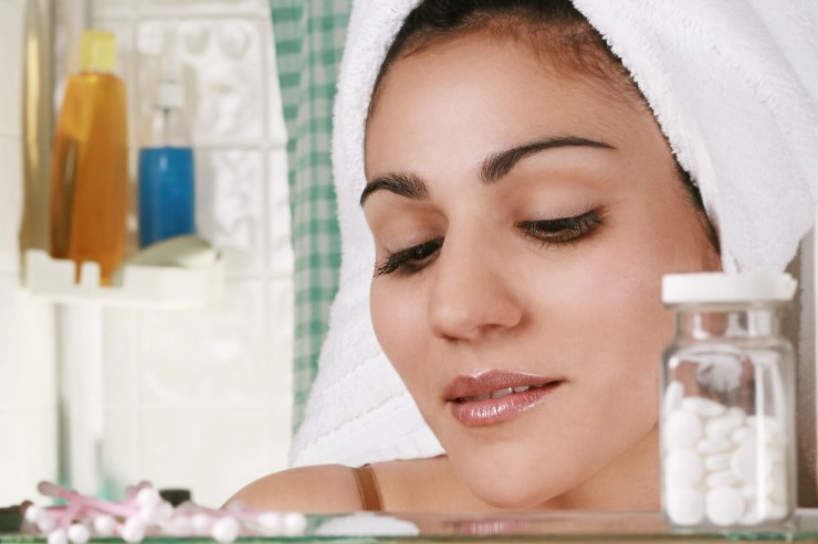 donna in bagno con scaffale medicine 