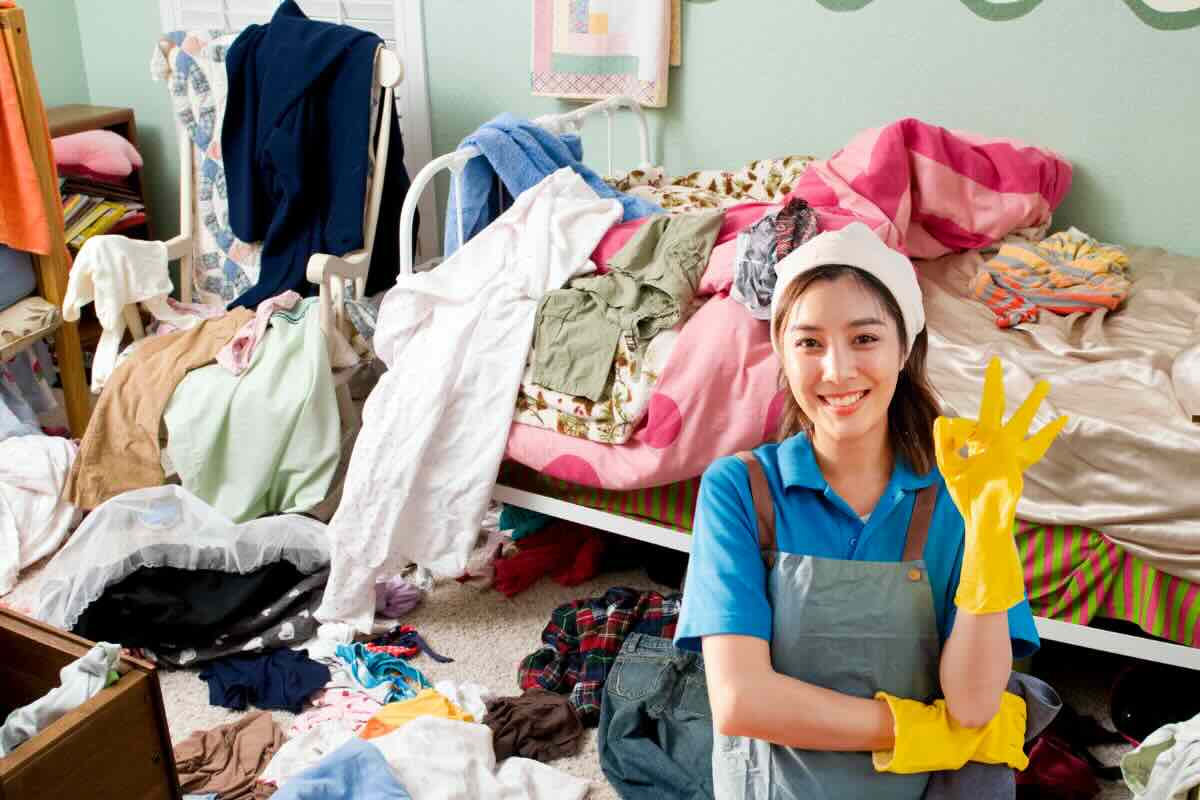 disordine casa e donna felice con guanti