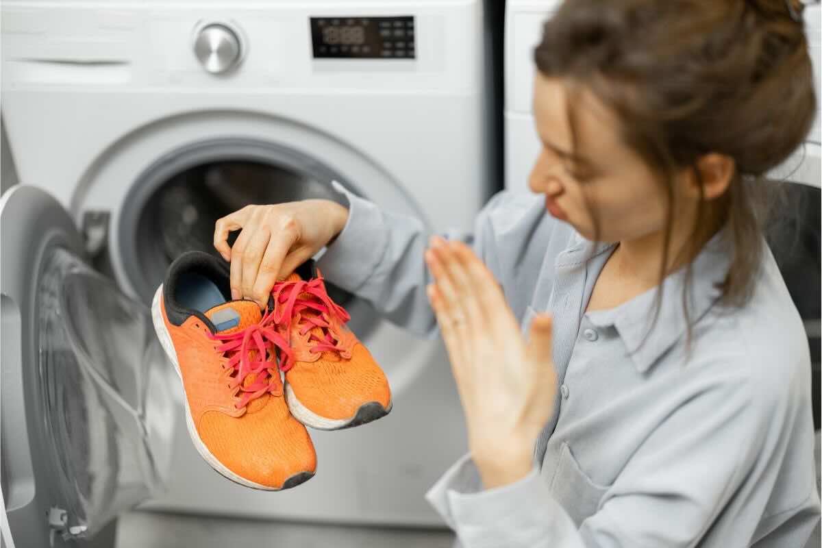Donna con scarpe davanti lavatrice