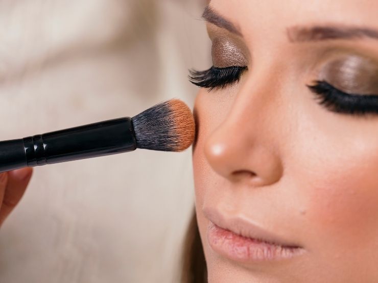 donna che mette il blush con il pennello