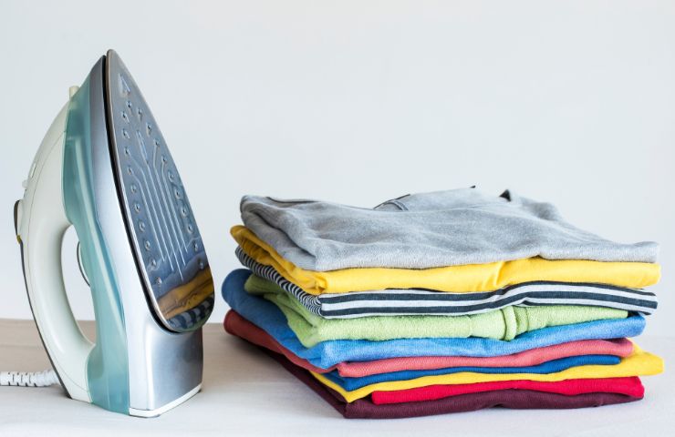 bucato stirato e piegato con ferro da stiro vicino
