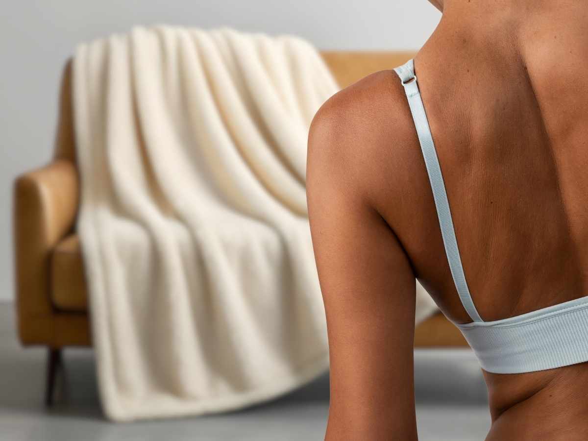 sfondo divano con coperta, un primo piano donna di spalle pelle abbronzata