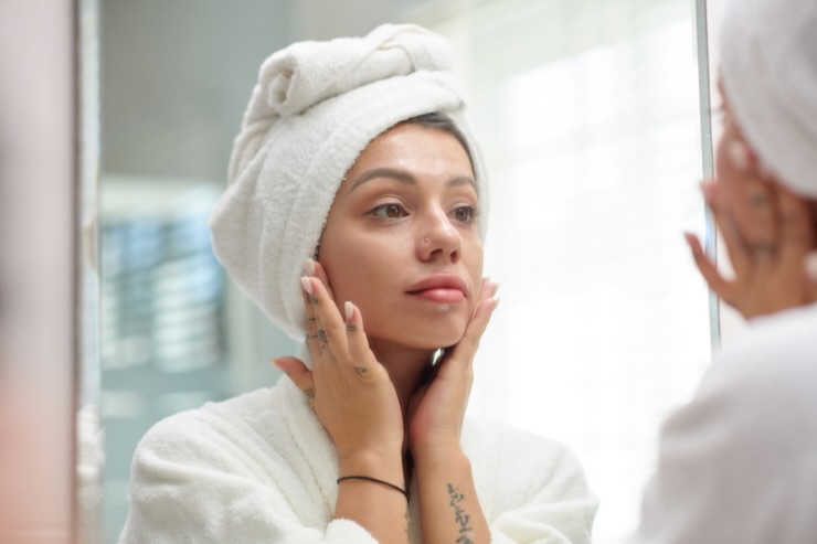 donna che mette crema sul viso