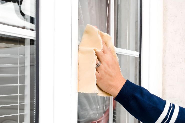 mano che pulisce vetri