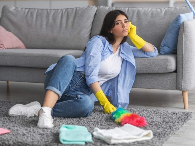 donna scocciata mentre fa le pulizie 