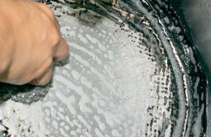 donna pulisce padella 