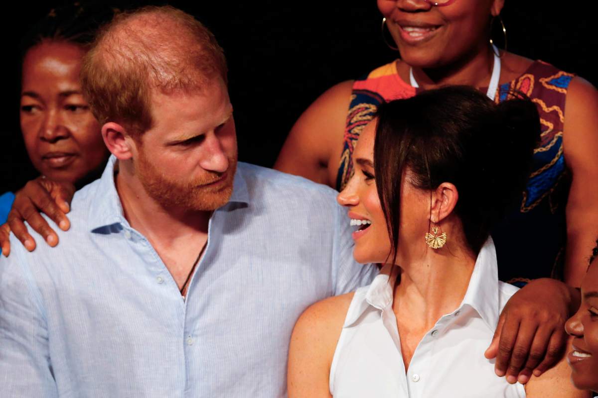 Harry e Meghan si guardano negli occhi, lei sorride