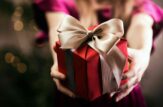 ragazza porge un regalo verso chi osserva
