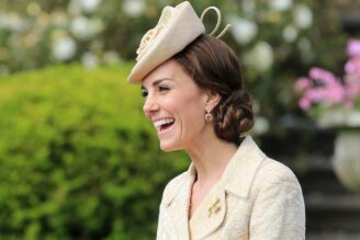 Kate Middleton sorride di profilo. Indossa un tailleur giallo con cappellino e i capelli raccolti.