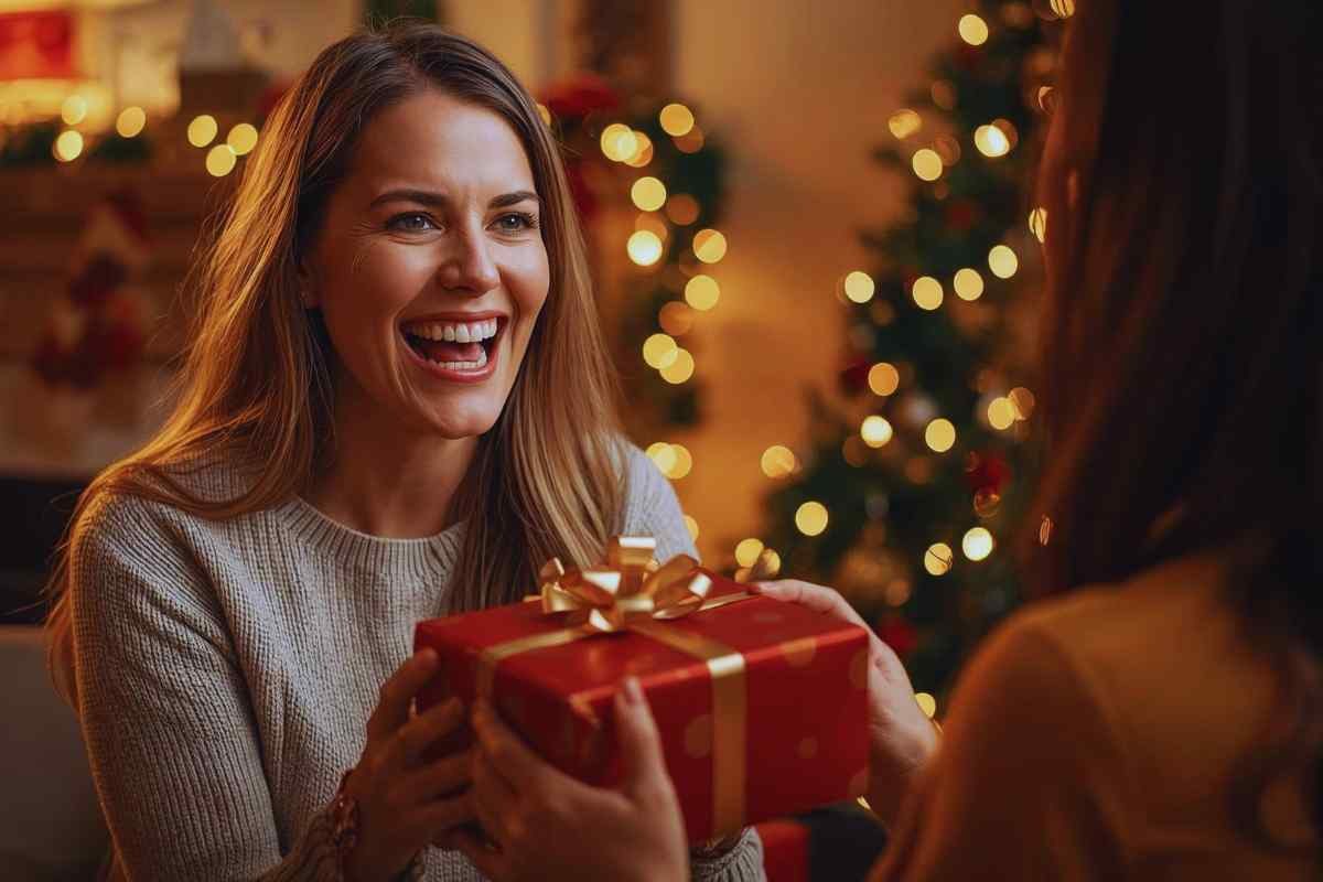 Donna felice con in mano un pacchetto regalo di Natale