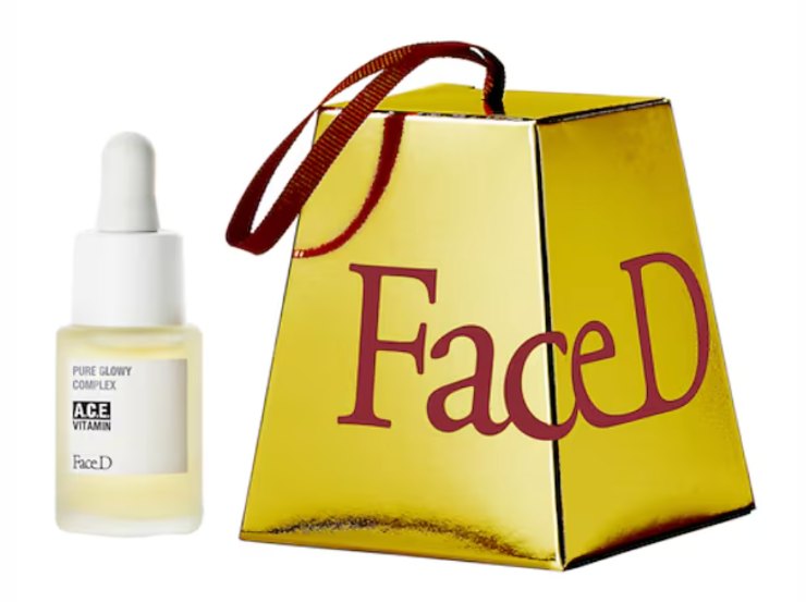 Il kit FaceD, il contenitore dorato a forma di panettone e il siero accanto a sinistra