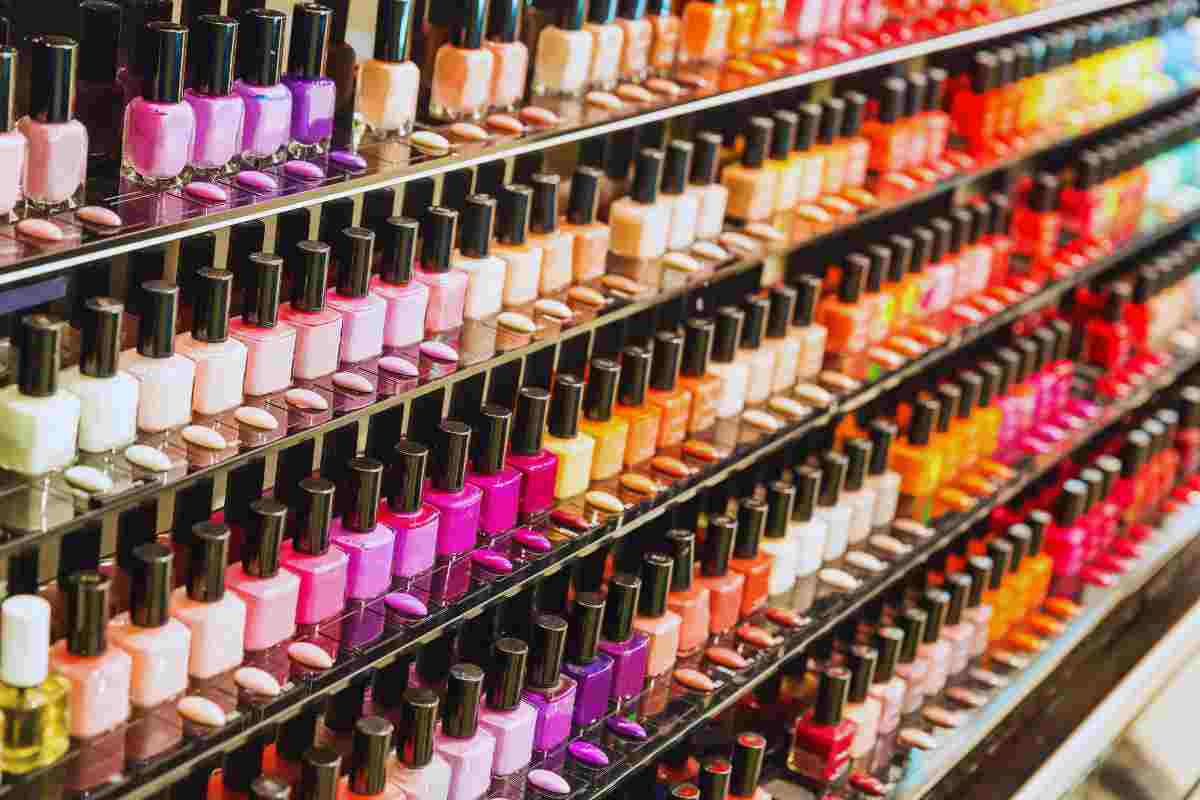 Uno scaffale pieno di smalti di tutti i colori