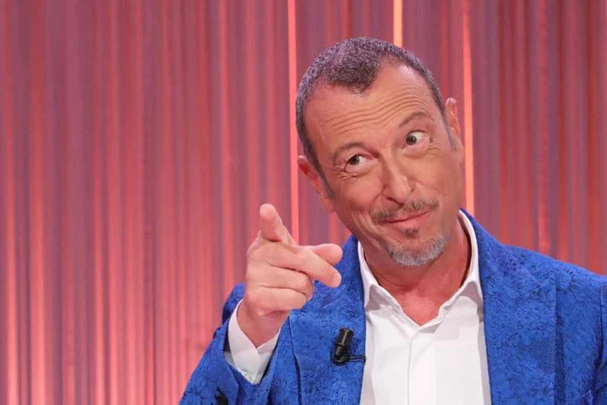 amadeus con la giacca azzurra nello studio di cinque minuti e il dito indice alzato per indicare