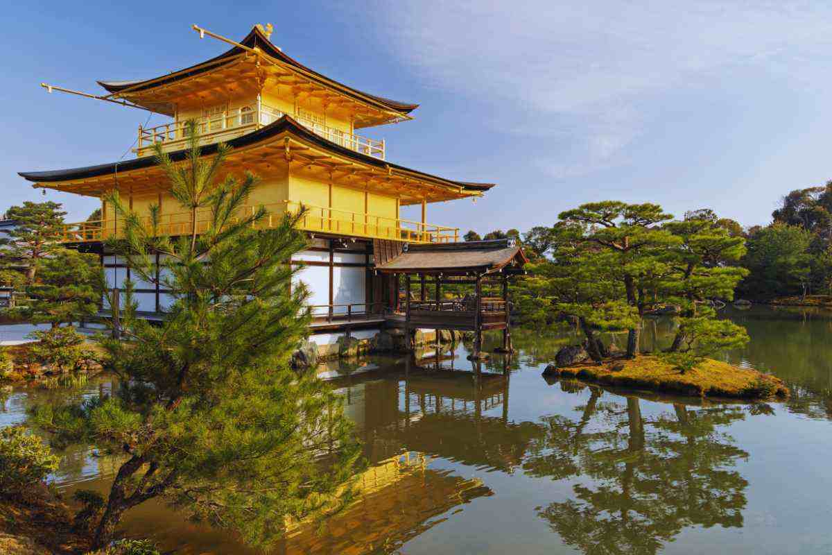 Una veduta di Kyoto con un tempio sulla sinistra immerso nella natura 