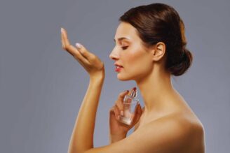 Una ragazza di profilo che si annusa il polso