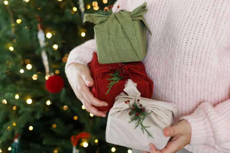 donna che mantiene tre regali di Natale